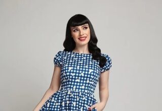 A woman dressed in a vintage blue and white checker'd dress and yellow shoes.