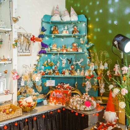 Christmas ornaments and decorations line the walls and shelving units in a store.