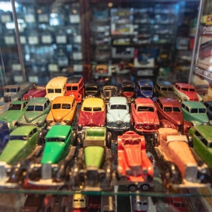 A glass shelf displays 30 vintage model cars.