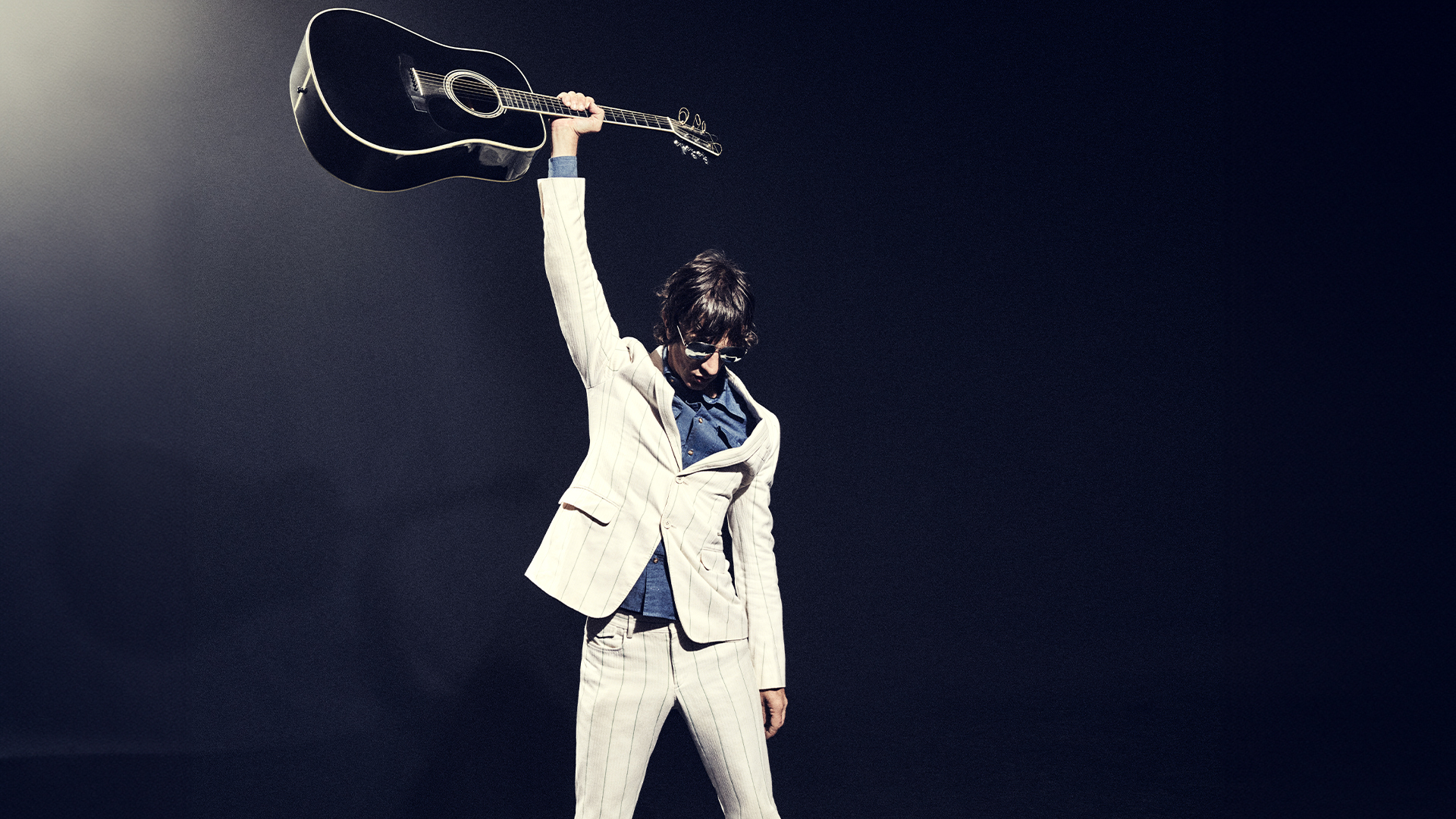 A photograph of Richard Ashcroft holding up a guitar.